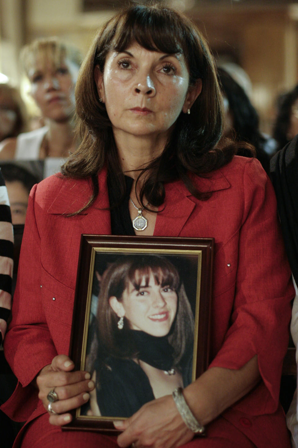 FILE - In this April 3, 2008 file photo, Susana Trimarco holds a picture of her missing daughter Maria de los Angeles "Marita" Veron, as she attends a Mass on the sixth anniversary of Marita's disappearance, in San Miguel de Tucuman, Argentina. Trimarco is known for her crusade to find her daughter Marita, who disappeared in 2002. A court in Argentina on Tuesday, April 8, 2014, has handed down sentences of 10 to 22 years in prison to 10 defendants accused of kidnapping and forcing into prostitution Marita whose disappearance raised global awareness about people trafficking. (AP Photo/Infoto, Julio Pantoja, File)