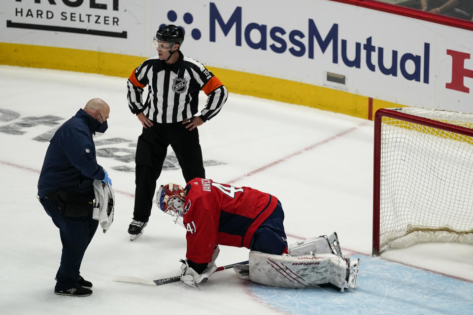 Washington Capitals goaltender Vitek Vanecek (41) receives attention during the first period of Game 1 of th team's NHL hockey Stanley Cup first-round playoff series against the Boston Bruins, Saturday, May 15, 2021, in Washington. Vanecek left the game. (AP Photo/Alex Brandon)