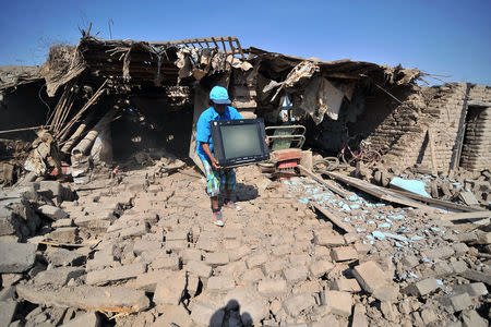 A man passes the debris of a building after a strong magnitude 7.1 earthquake struck the coast of southern Peru, in Acari, Arequipa , Peru, January 14, 2018. REUTERS/Diego Ramos