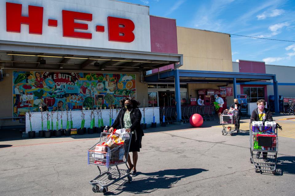 Masked shoppers leave the S. Congress H-E-B on  March 3 in Austin, Texas. Texas Gov. Greg Abbott rescinded a mask mandate, but he cautioned Texans to keep wearing them for their own safety.