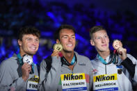 First placed Italy's Gregorio Paltrinieri, center, second placed Bobby Finke, left, of the United States and third placed Florian Wellbrrock of Germany celebrate after the men's 1500m freestyle final at the 19th FINA World Championships in Budapest, Hungary, Saturday, June 25, 2022. (AP Photo/Petr David Josek)