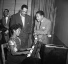 <p> After a December concert at Carnegie Hall in New York City, musician Sarah Vaughan takes to the piano with Duke Ellington and Billy Eckstine. Could it be Christmas tunes these stars were singing?</p>