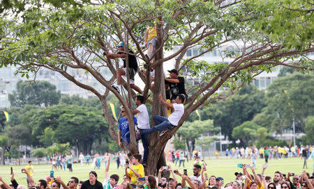 Supporters take pictures as Brazil's new President Jair Bolsonaro drives past before his swear-in ceremony, in Brasilia, Brazil January 1, 2019. REUTERS/Ricardo Moraes