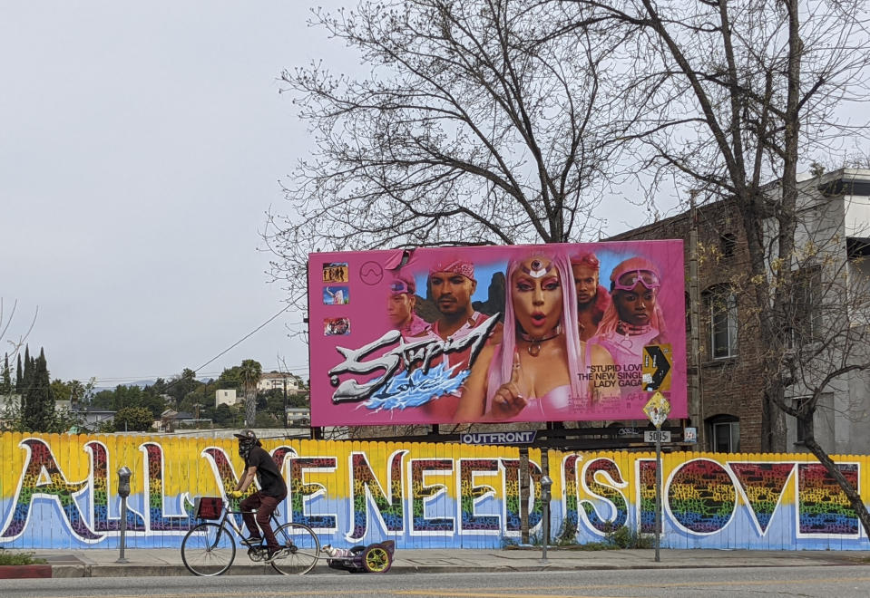 A man wears a bandana as he rides with his Chiuhuaha dog on Sunset Blvd., in Los Angeles Tuesday, March 31, 2020. Gov. Gavin Newsom says California's extraordinary efforts to keep people home have bought the time needed to prepare for an expected peak surge of coronavirus cases in coming weeks. A spike of new cases has not come as quickly as expected. However, Newson was reluctant to say Tuesday whether ultimately that means the impact won't be nearly as dire as first predicted. He said people can't let down their guards and need to continue to stay home. (AP Photo/Damian Dovarganes)