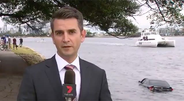 A large boat can be seen passing the submerged car as 7 News reporter Jamie Freestone speaks at the scene. Source: 7 News