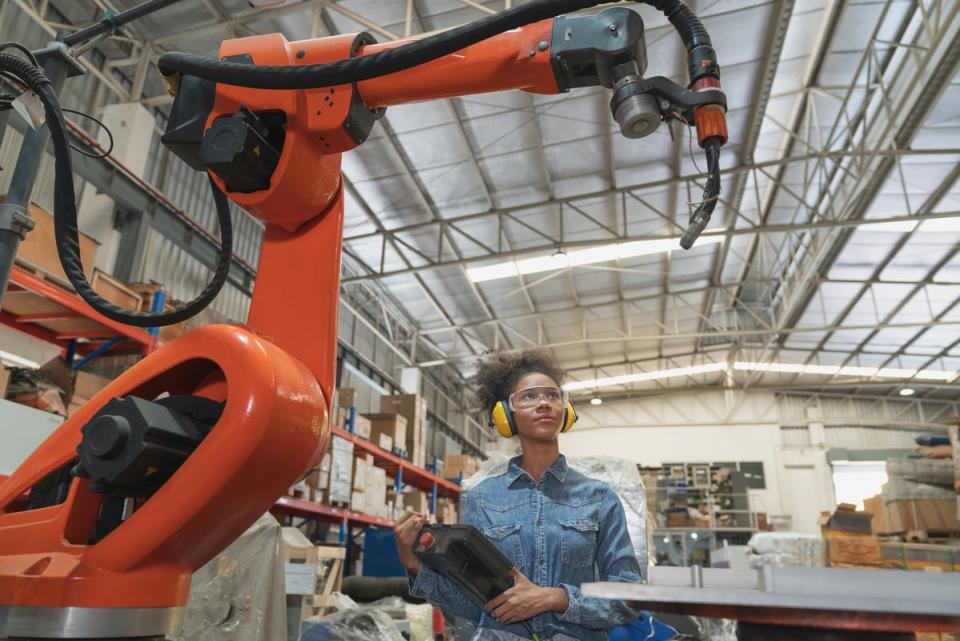 A person looking at industrial machinery in a warehouse. 