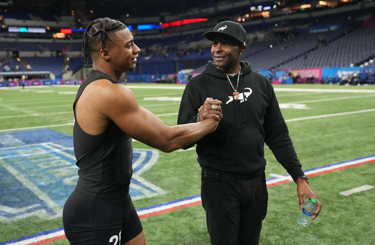 Jerry Rice meets up with his son, USC wide receiver Brenden Rice, on the field during the 2024 NFL scouting combine.
