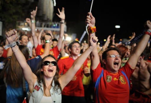 Supporters of the Spanish national football team celebrate after Spain defeated Portugal during the Euro 2012 Championships on a giant screen near the Santiago Bernabeu Stadium in Madrid. Defending champions Spain beat Portugal 4-2 on penalties after their Euro 2012 semi-final finished 0-0 after extra-time