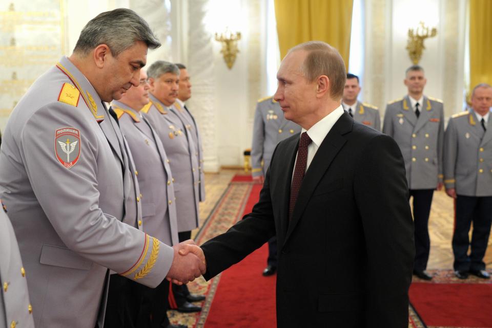 Russian President Vladimir Putin, right, shakes hands with Head of the Russian Interior Ministry's branch in the North Caucasus Kazimir Botashev at the presentation ceremony of the top military brass in the Kremlin in Moscow, Russia, Friday, March 28, 2014. Russia's president says Ukraine could regain some arms and equipment of military units in Crimea that did not switch their loyalty to Russia. (AP Photo/RIA-Novosti, Alexei Druzhinin, Presidential Press Service)