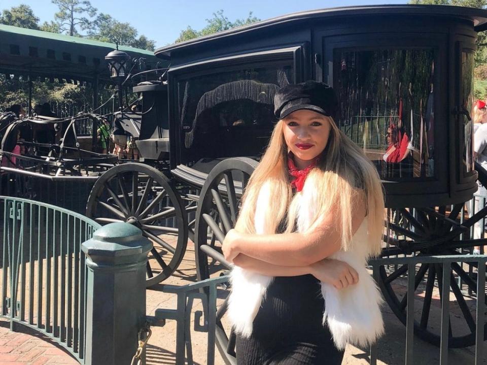 kayleigh standing in front of carriage at haunted mansion disney world