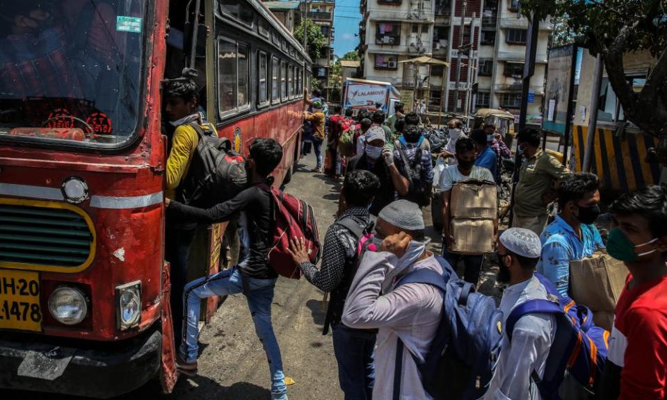 Migrant workers board a bus in Mumbai to go to their home towns.