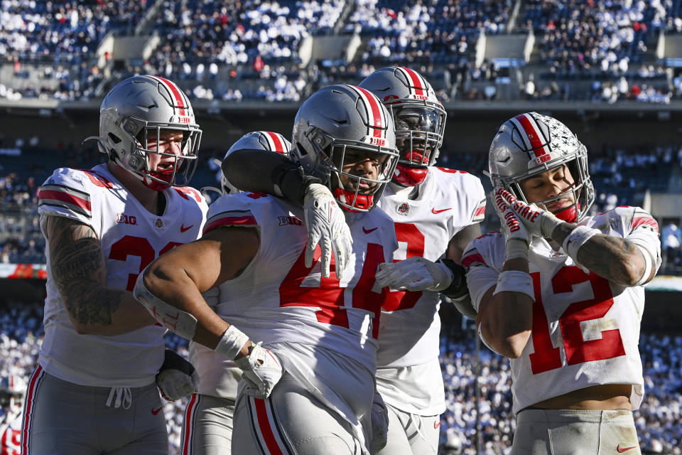 Ohio State defensive end J.T. Tuimoloau (44) celebrates with his teammates Jack Sawyer (33), Zach Harrison (9) and Lathan Ransom (12) after returning an interception for a touchdown during the fourth quarter of an NCAA college football game against Penn State, Saturday, Oct. 29, 2022, in State College, Pa. (AP Photo/Barry Reeger)