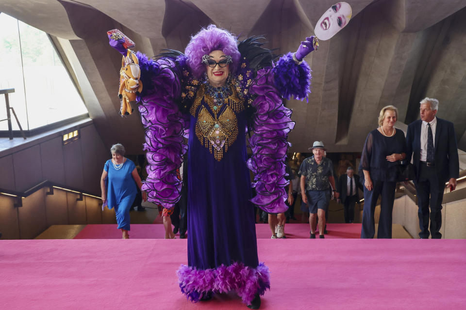 A guest arrives dressed as Dame Edna Everage for the State Memorial Service for Australian comedian and actor Barry Humphries at the Sydney Opera House in Sydney, Friday, Dec. 15, 2023. King Charles III has paid tribute to the late Barry Humphries at a state memorial service with a message that recalled the monarch's own apprehension when the comedian's alter ego Dame Edna Everage played a prank on him in a royal box a decade ago (David Gray/Pool Photo via AP)