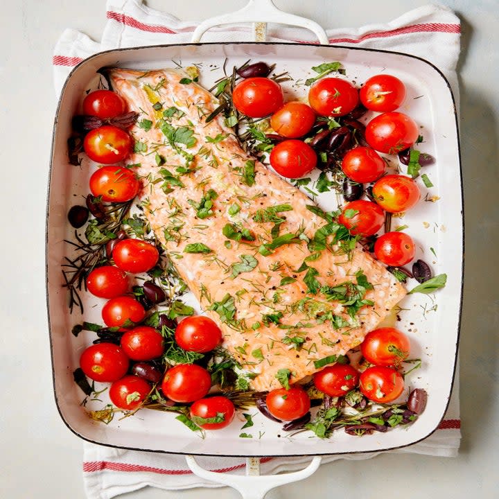 Salmon in a baking dish with cherry tomatoes.