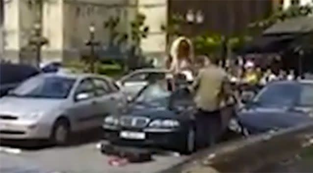 The moment the woman jumps onto the vehicle and smashes a guitar on the car. Source: Supplied.