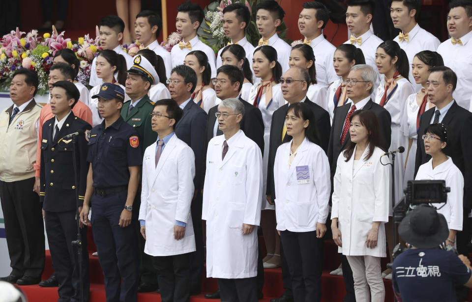 Epidemic prevention personnel lead the national anthem during the National Day celebrations in Taipei, Taiwan, Saturday, Oct. 10, 2020. (AP Photo/Chiang Ying-ying)