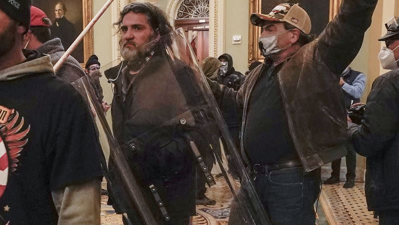 Rioters, including Dominic Pezzola, center with police shield, are confronted by U.S. Capitol Police officers outside the Senate Chamber inside the Capitol on Jan. 6, 2021, in Washington. Pezzola, a former member of the far-right Proud Boys extremist group who smashed a window at the U.S. Capitol in the building’s first breach of the riot, was sentenced to 10 years in prison.