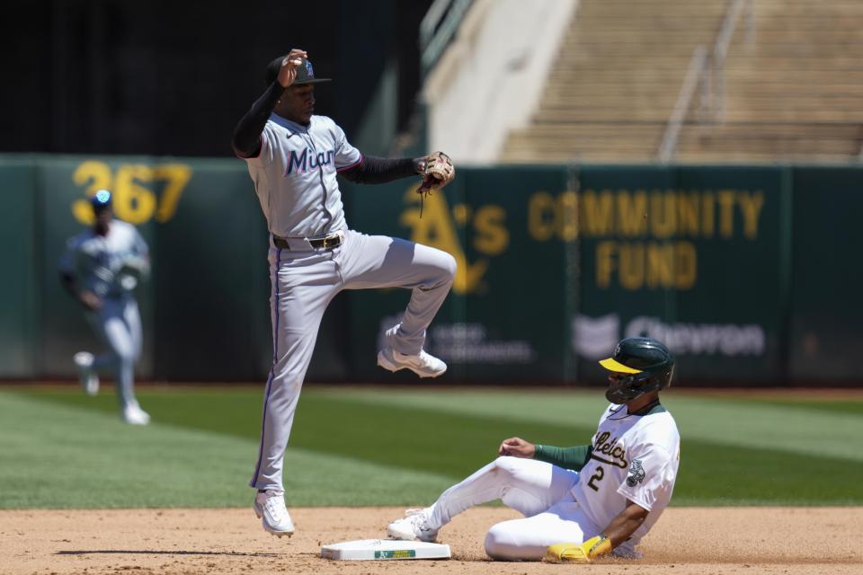 Oakland Athletics' Darell Hernaiz, right, slides safely at second next to Miami Marlins shortstop Tim Anderson during the fourth inning of a baseball game, Sunday, May 5, 2024, in Oakland, Calif. Athletics' Kyle McCann reached first on the throwing error by Marlins' Josh Bell. (AP Photo/Godofredo A. Vásquez)