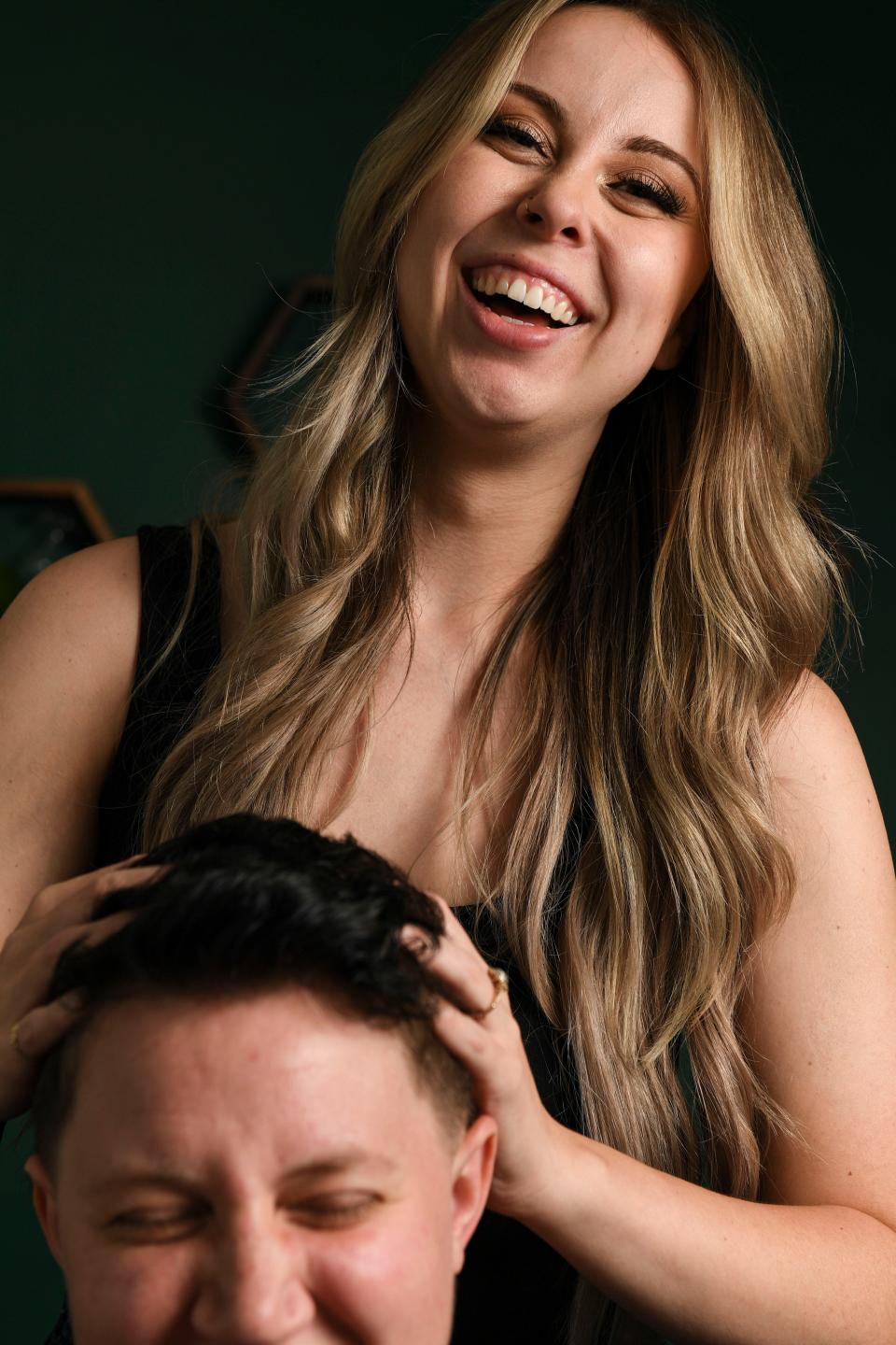 Bailey Lavender, social media influencer and hairstylist, laughs with her partner and manager, Charley McFarland, in her hair studio where she films most of her content on Wednesday, Aug. 23, 2023.