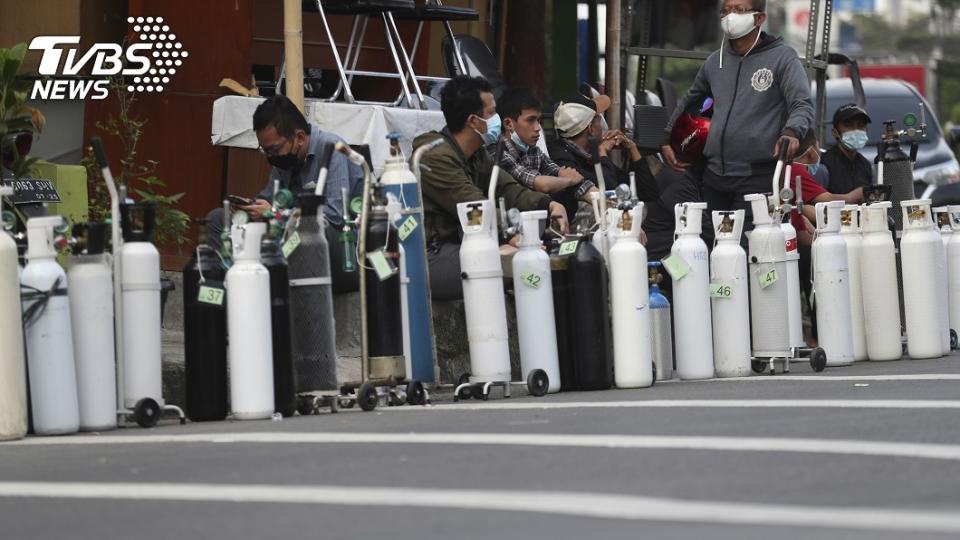  圖／達志影像美聯社，許多印尼民眾買不到氧氣，乾脆把氧氣瓶放在補充站前排隊。