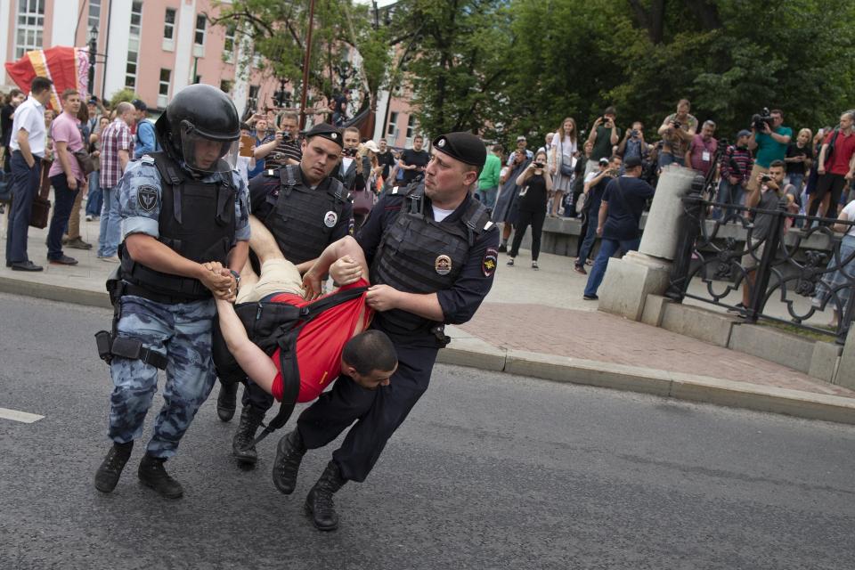 Police officers detain a protester during a march in Moscow, Russia, Wednesday, June 12, 2019. Police and hundreds of demonstrators are facing off in central Moscow at an unauthorized march against police abuse in the wake of the high-profile detention of a Russian journalist. More than 20 demonstrators have been detained, according to monitoring group. (AP Photo/Alexander Zemlianichenko)