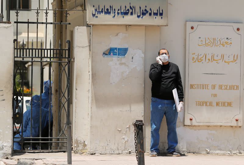 A man wearing protective face mask and gloves stands outside the Institute of Research for Tropical Medicine amid concerns about the spread of the coronavirus disease (COVID-19), in Cairo