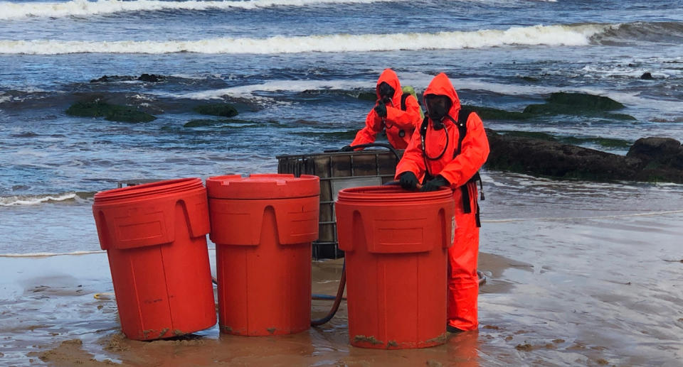 Hazmat crews remove the contents of a container at Newcastle Beach