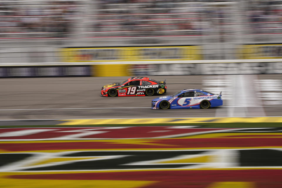 Martin Truex Jr. (19) and Kyle Larson (5) drive during a NASCAR Cup Series auto race Sunday, March 7, 2021, in Las Vegas. (AP Photo/John Locher)