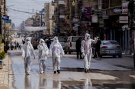 Medical workers oversee the disinfection of the streets to prevent the spread of coronavirus in Qamishli, Syria, Tuesday, March 24, 2020. (AP Photo/Baderkhan Ahmad)