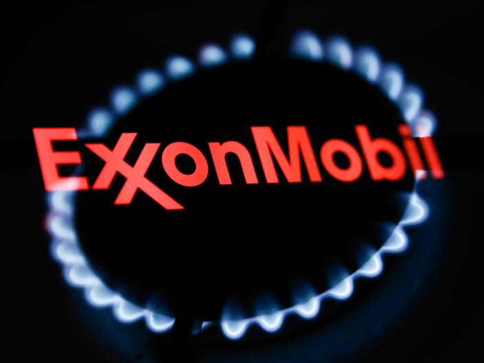 ExxonMobil logo displayed on a phone screen are seen in this multiple exposure illustration photo taken in Krakow, Poland on January 22, 2022.