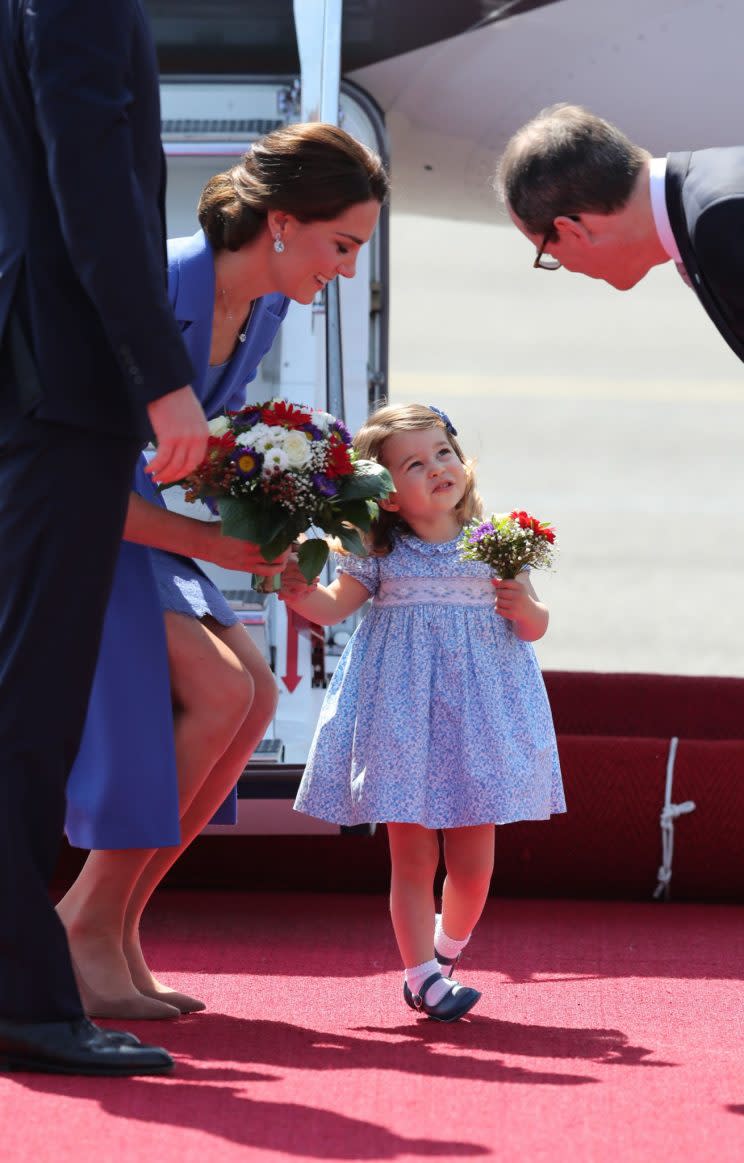 Princess Charlotte accepts a posy of flowers upon arriving in Germany