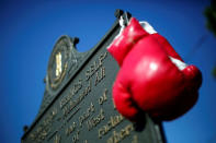 Boxing gloves are seen hanging on a historical marker outside Muhammad Ali's childhood home in Louisville, Kentucky, U.S., June 10, 2016. REUTERS/Carlos Barria