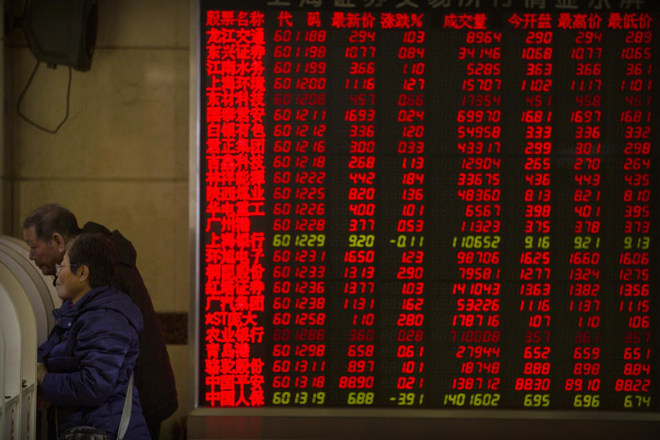 In this Tuesday, Nov. 19, 2019 photo, Chinese investors use computer terminals as they monitor stock prices at a brokerage house in Beijing. Shares retreated in Asia on Wednesday after Japan reported its worst monthly decline in exports in three years. (AP Photo/Mark Schiefelbein)