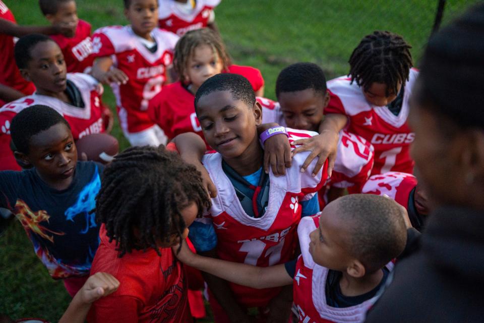 Larry Thompson, center, of Detroit is surrounded with other members of the West Side Cubs 8U football team as they gather in prayer at the end of practice at McCabe Field in Detroit on Tuesday, September 12, 2023. More than just youth football and cheerleading teams, the West Side Cubs represent a vital community institution with a 66-year history.