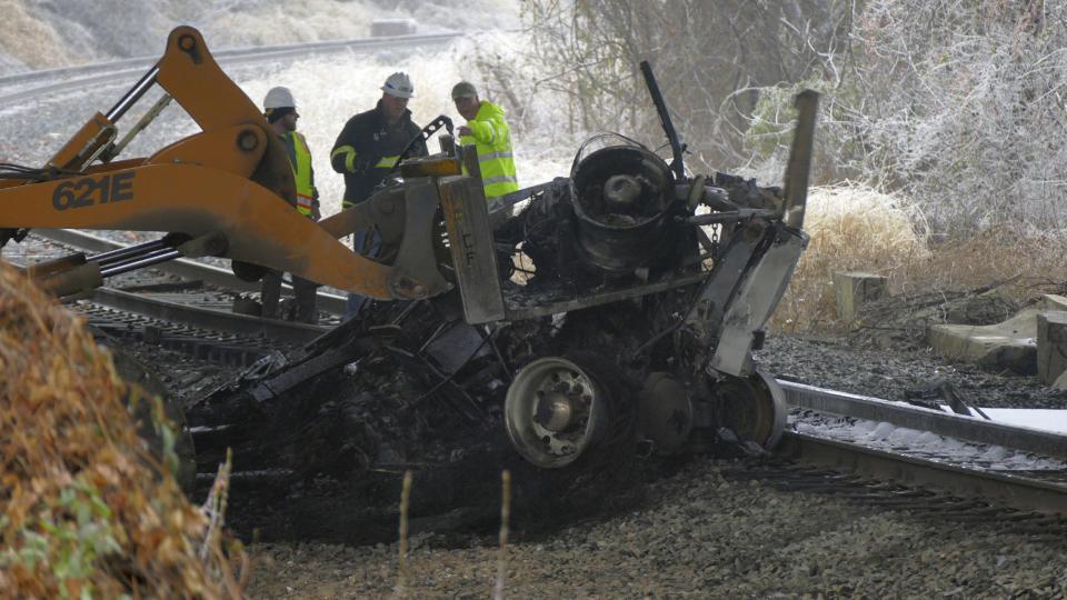 Seen from the Interstate 95 overpass from Grove Street in southwest Baltimore, Md., emergency workers extract the wreckage of a tractor trailer from railroad tracks after it fell off a bridge and exploded, in a series of accidents that shut down I-95 on Saturday, Dec. 17, 2016. An ice storm created slick conditions, sparking a chain reaction pile-up involving dozens of vehicles. (Karl Merton Ferron/The Baltimore Sun via AP)