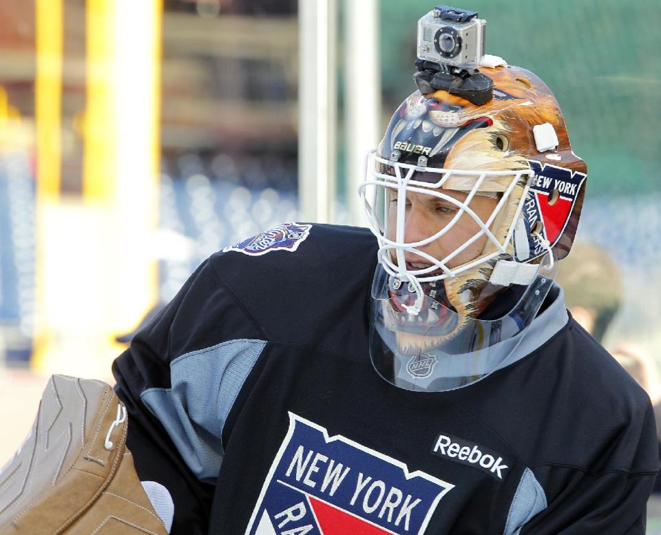 FILE - In this Sunday Jan. 1, 2012 file photo, New York Rangers' goalie Martin Biron, sporting a helmet camera, warms up during practice for the Winter Classic hockey game, in Philadelphia. For adventure athletes, it's the new essential: a video of their exploits. Now only video action will do for a shoot-it-and-share-it generation of skiers and skydivers, snowboarders and bike riders. (AP Photo/Tom Mihalek, File)