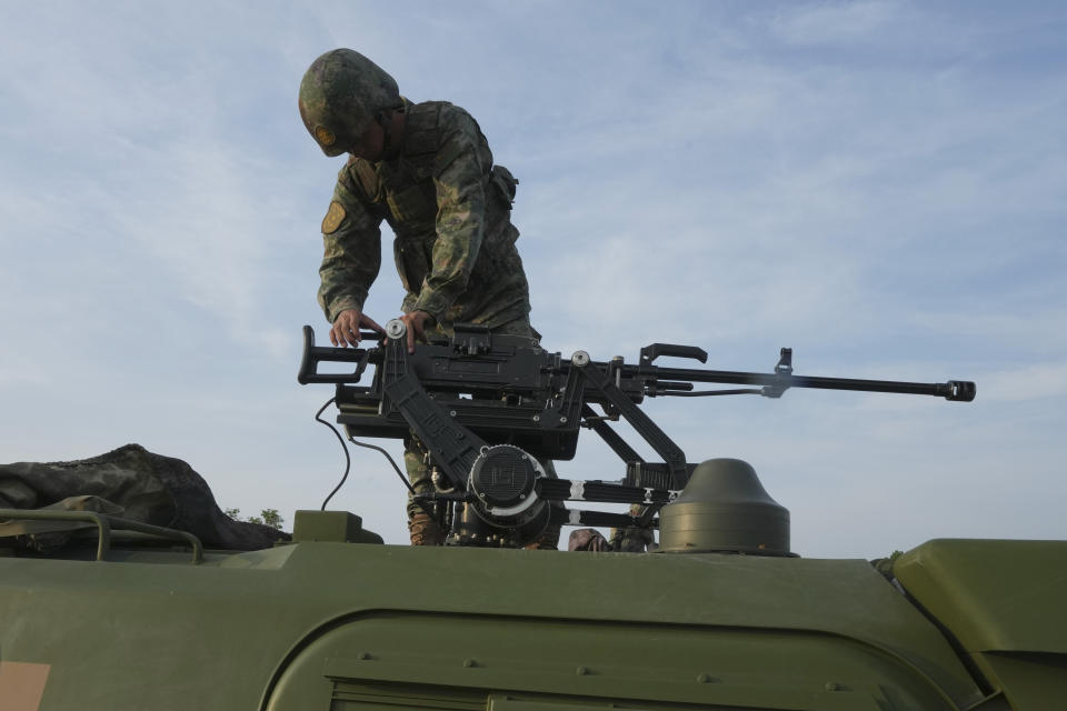 A Chinese army prepares a weapon on an armoured vehicle before a participating in the Golden Dragon military exercise in Svay Chok village, Kampong Chhnang province, north of Phnom Penh Cambodia, Thursday, May 16, 2024. Cambodia and China on Thursday kicked off their annual Golden Dragon military exercise to strengthen cooperation and exchange military experiences. (AP Photo/Heng Sinith)