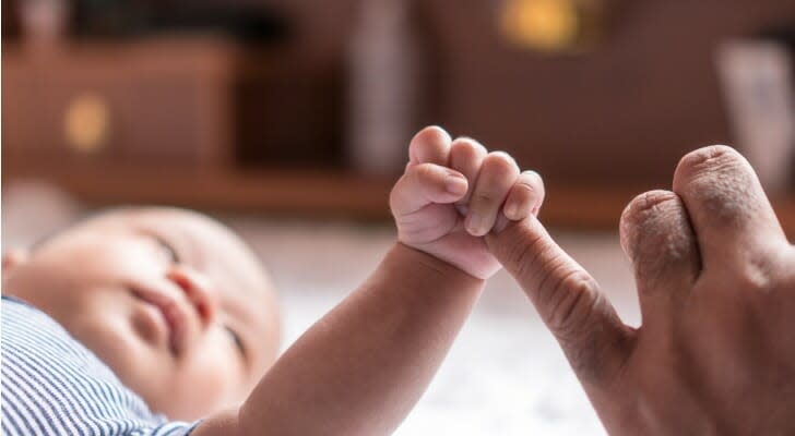 Newborn baby holding parent's finger