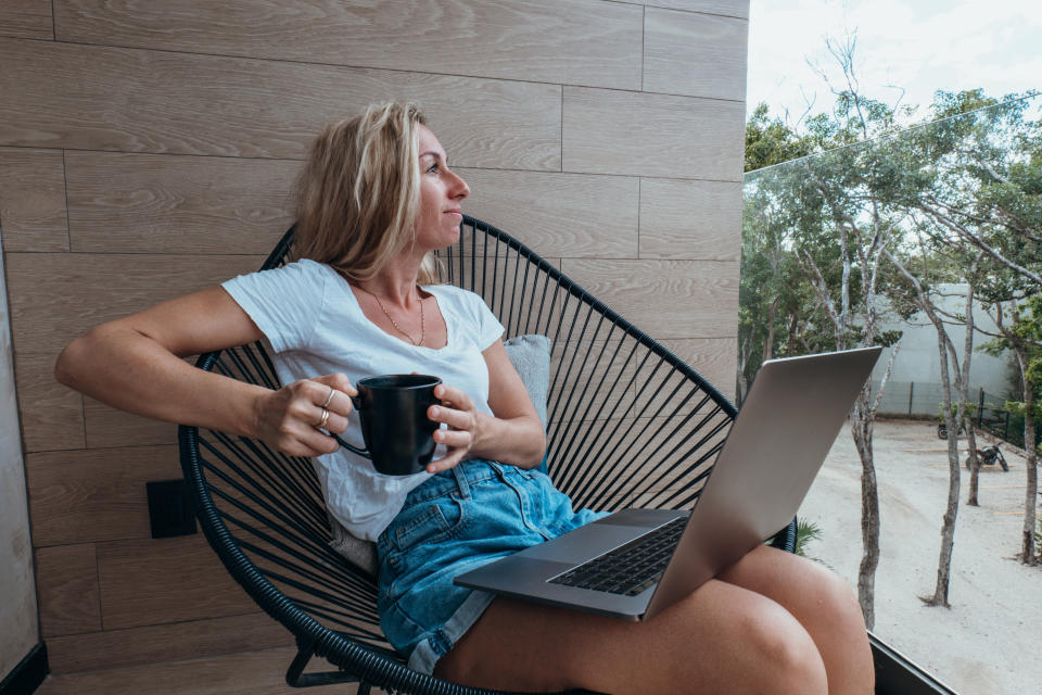 Young woman working online, sunlight coming in the room in the morning sunrise