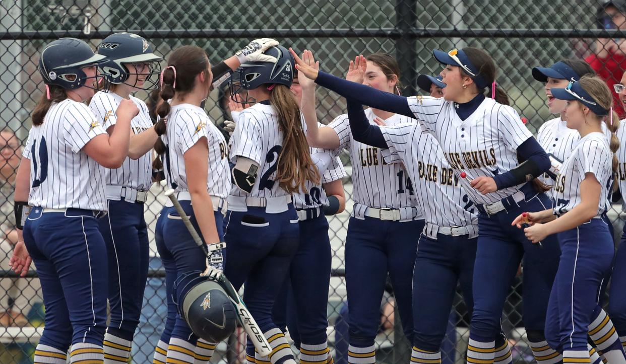 Tallmadge senior Ashlyn Severns (20) is mobbed by teammates at the plate after her home run against Kent Roosevelt on April 10 in Tallmadge.