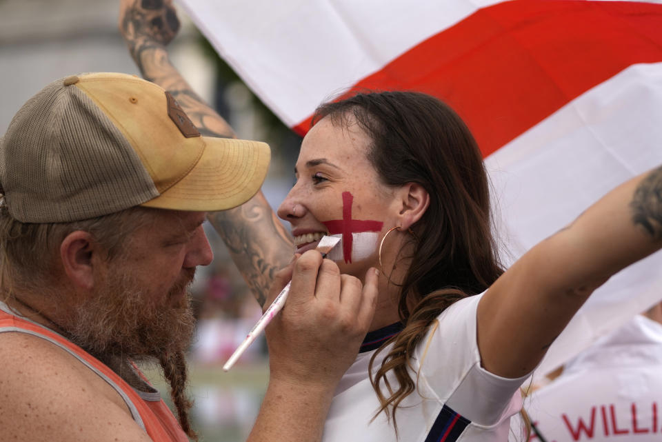 A supporter has the England flag painted on her face in the fan zone in Trafalgar Square as fans gather to watch on a big screen the final of the Women's Euro 2022 soccer match between England and Germany being played at Wembley stadium in London, Sunday, July 31, 2022. (AP Photo/Frank Augstein)