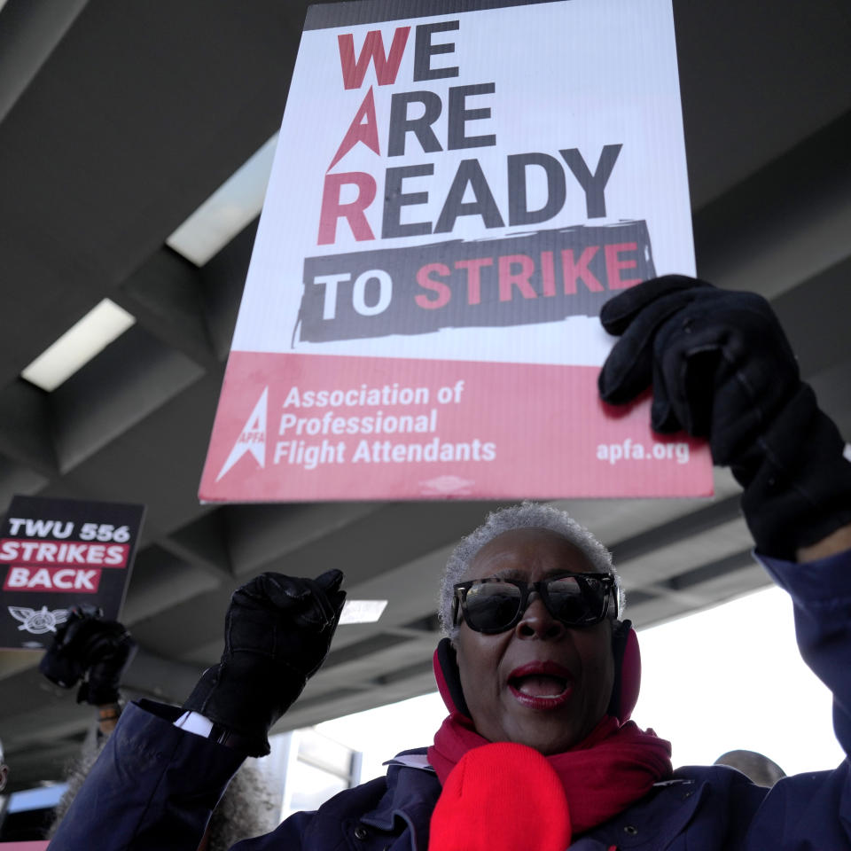 A flight attendant holds a sign during a protest at O'Hare International Airport in Chicago, Tuesday, Feb. 13, 2024. Three separate unions representing flight attendants at major U.S. airlines are picketing and holding rallies at 30 airports on Tuesday as they push for new contracts and higher wages. (AP Photo/Nam Y. Huh)
