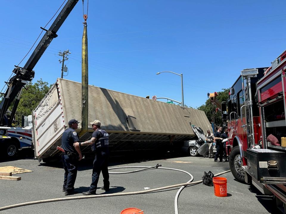 First responders lift the trailer of a cattle truck off of a vehicle near Waterloo and Alpine roads in Stockton on May 16, 2023.