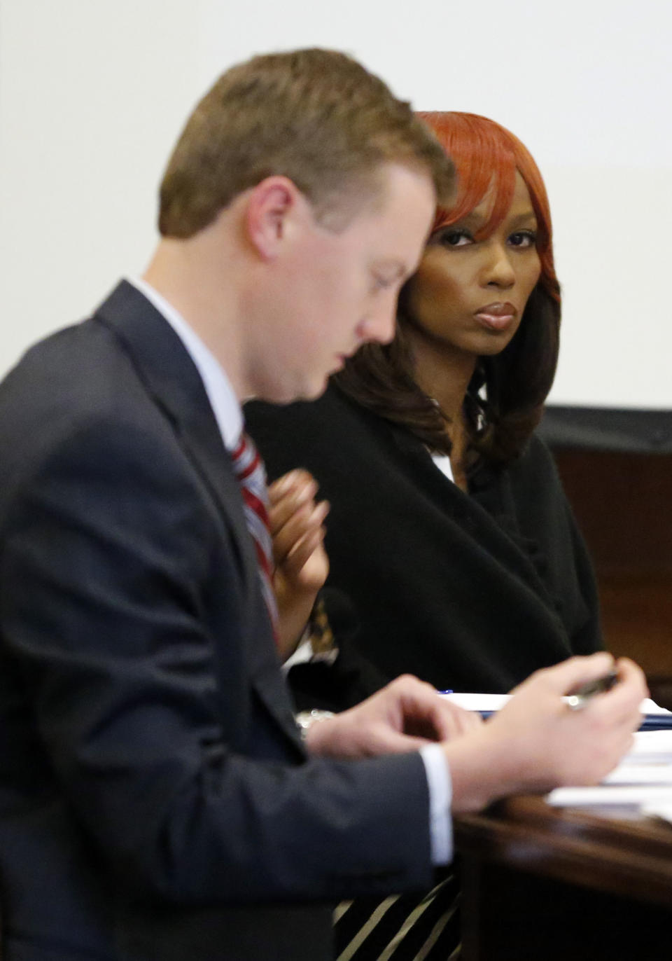 Natasha Stewart, also known as Pebbelz Da Model, looks toward reporters while Jared Tomlinson, one of her attorneys, works on jury instructions in county court in Jackson, Miss., Friday, Jan. 31, 2014. Stewart is charged with depraved-heart murder in the death of 37-year-old Karima Gordon, of Atlanta. She allegedly helped arrange the unlicensed buttocks injections that prosecutors say killed Gordon in 2012. The jury begun deliberations Friday afternoon. (AP Photo/Rogelio V. Solis)