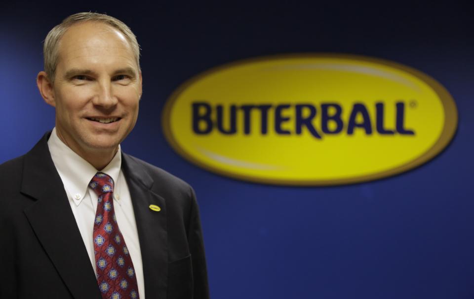 This Nov. 22, 2013 photo shows Butterball Turkey CEO Rod Brenneman posing in front of a sign at a Turkey Talk-Line facility in Naperville, Ill. (AP Photo/M. Spencer Green)