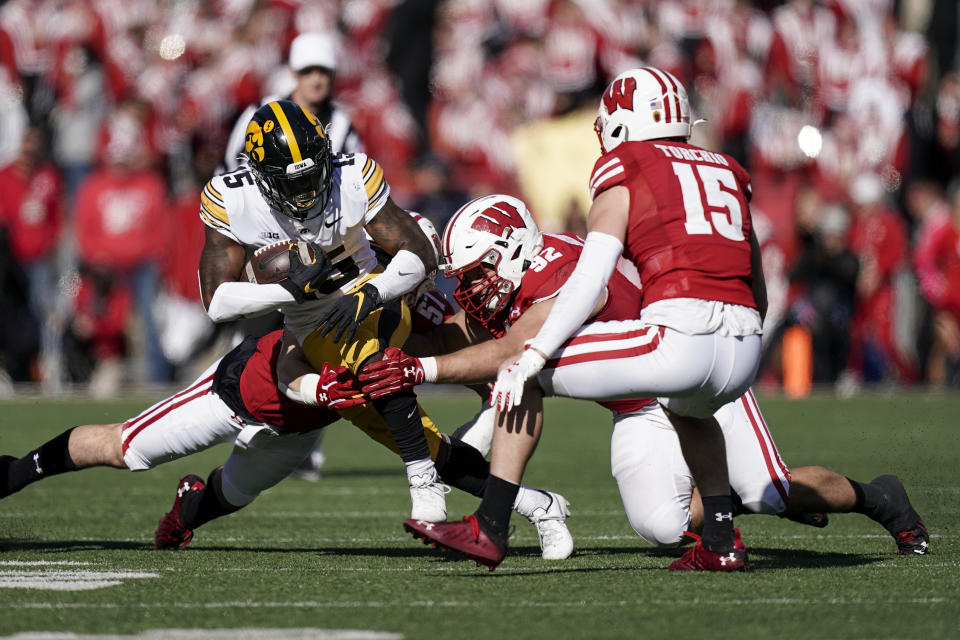 Wisconsin linebacker Jack Sanborn (57) and defensive end Matt Henningsen (92) wrap up Iowa running back Tyler Goodson (15) during the second half of an NCAA college football game Saturday, Oct. 30, 2021, in Madison, Wis. Wisconsin upset Iowa 27-7. (AP Photo/Andy Manis)