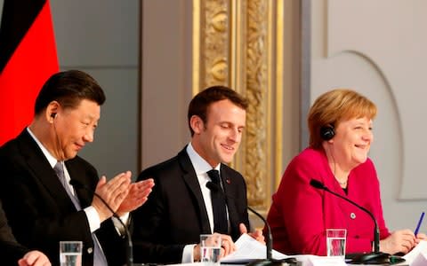 Chinese President Xi Jinping, French President Emmanuel Macron and German Chancellor Angela Merkel hold a press conference at the Elysee presidential palace in Paris - Credit: &nbsp;THIBAULT CAMUS/AFP