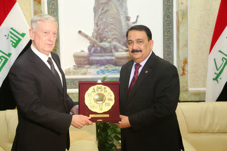 U.S. Defense Secretary Jim Mattis (L) receives a gift from Iraq's Defence Minister Erfan al-Hiyali during a visit to Baghdad, Iraq February 20, 2017.