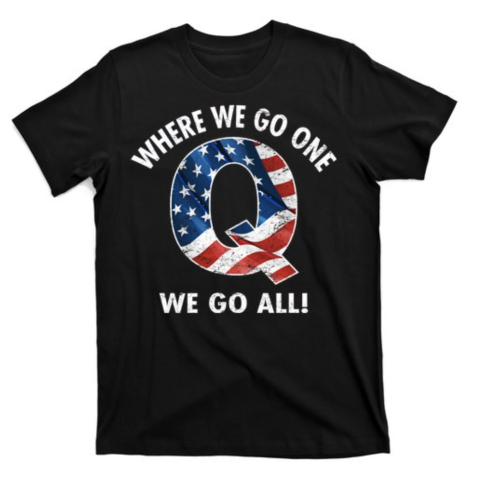 A black QAnon T-shirt has a large "Q" designed with the US flag's stars and stripes, framed by the words "where we go one, we go all" above and below it