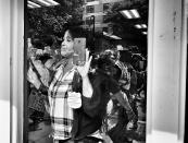 <p>A woman peers through the window of a salon at participants marching in a counterprotest against a “free speech” rally staged by conservative activists Aug. 19 in Boston (Photo: Holly Bailey/Yahoo News) </p>